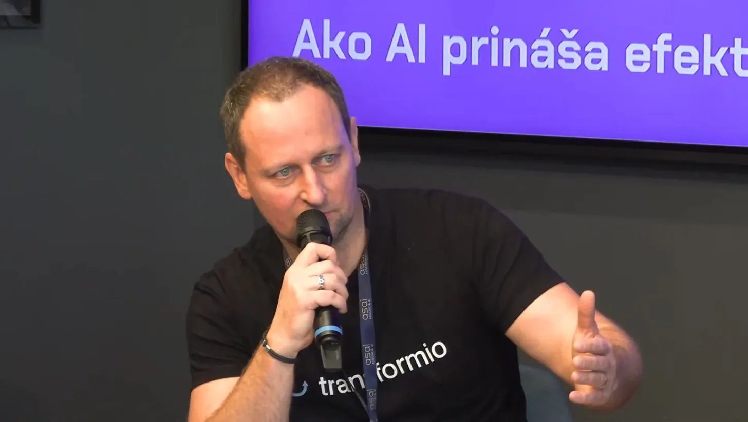 Braňo Šmidt zblízka s mikrofónom, pri rozprávaní gestikuluje rukou.